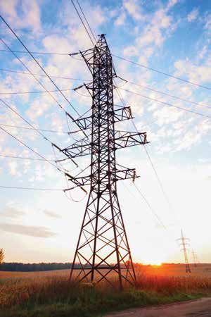 A transmission tower viewed from below against the evening sky.